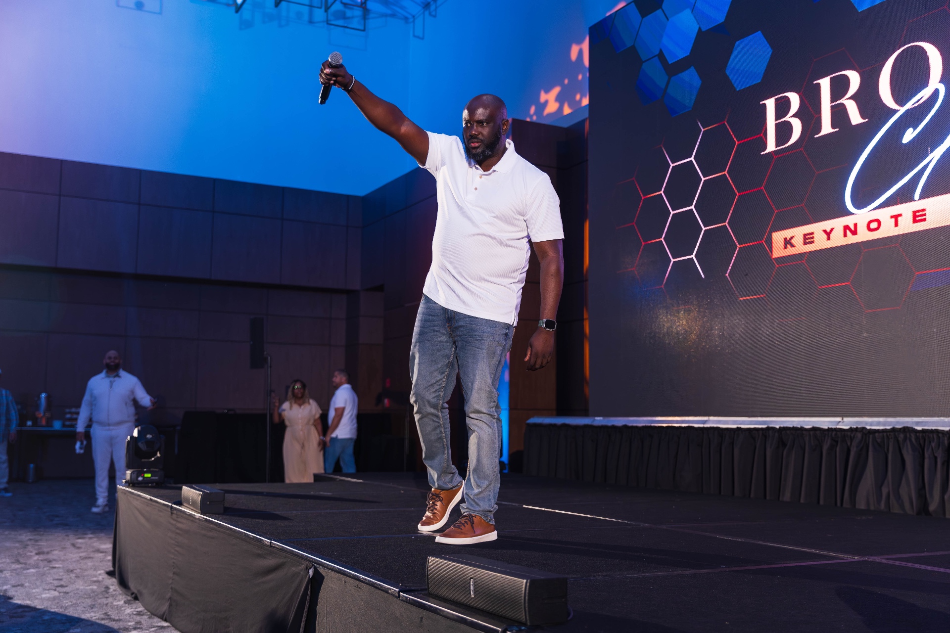 Brown on the keynote stage, mic raised
